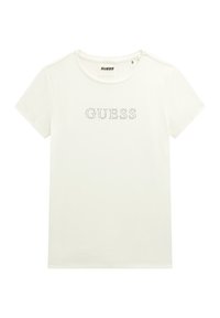 T-shirt blanc à manches courtes en coton avec un col rond et un logo "GUESS" en strass. Présente une texture simple et lisse.