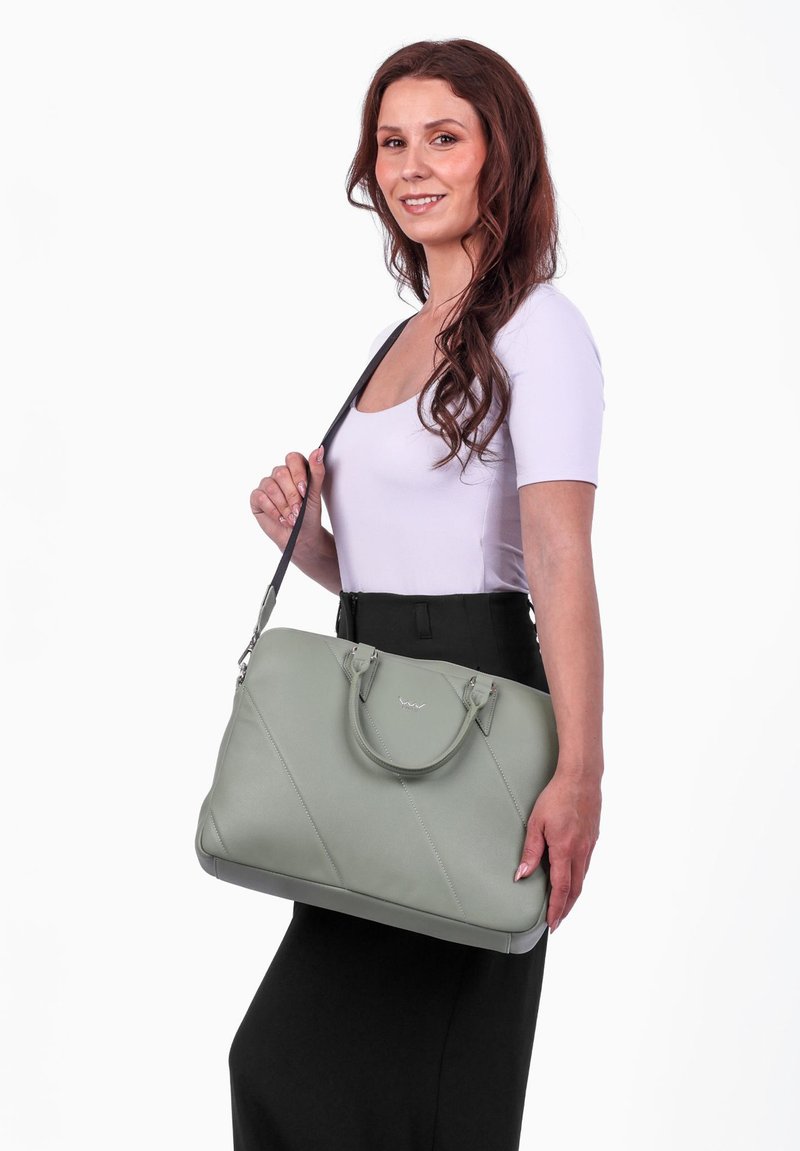 Grüne Leder-Handtasche mit diagonaler Naht, doppelten Traggriffen und einem abnehmbaren Schulterriemen. Glatte Oberfläche mit dezentem Markenlogo.