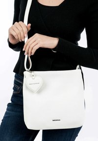 Sac de épaule en cuir blanc au design structuré, avec une étiquette en forme de cœur embossée avec "EMILY & NOAH" et une bandoulière détachable.