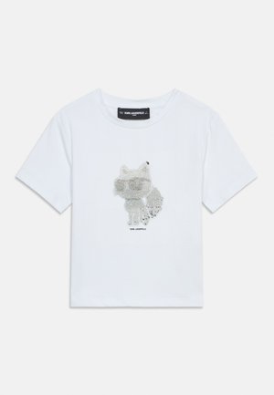 Valge lühikeste varrukatega laste T-särk hõbedaste litritega kassi kujundusega ja „Karl Lagerfeld“ brändinguga kassi all.