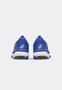 Des chaussures de sport bleues avec une surface texturée et une semelle blanche. Équipées d'une languette au talon et d'accents réfléchissants avec le texte "SOLUTION SPEED FF".