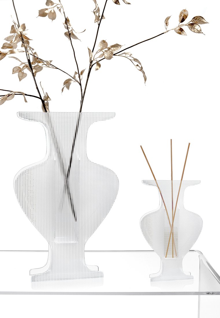 Vasi in vetro trasparente con un motivo testurizzato, uno grande e uno piccolo, che contengono foglie d'oro sottili e canne di legno. Forme moderne e geometriche.