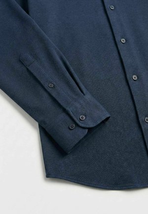 Mørkeblå skjorte med lange ermer, knapper på mansjettene og knapper foran, på en lys bakgrunn.