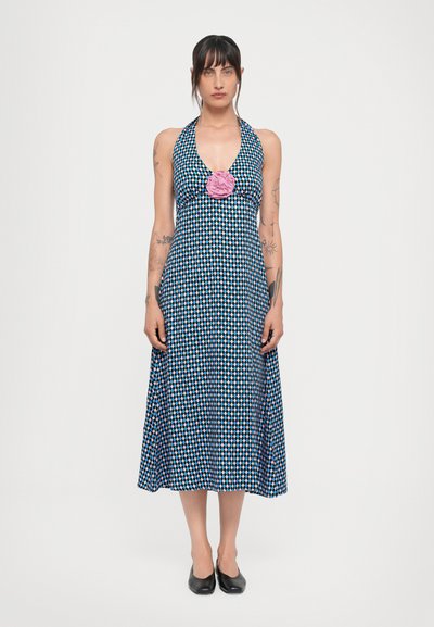 Abito halter in blu con un motivo geometrico in rosa e bianco. Presenta un dettaglio floreale arricciato rosa sul collo. Design a mezza lunghezza.