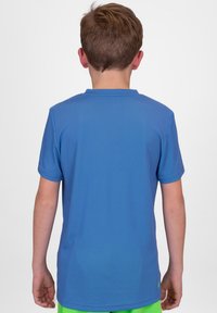 Camiseta deportiva azul de manga corta con textura de malla, diseño de cuello redondo y un logo cerca del dobladillo. El modelo se muestra de espaldas.