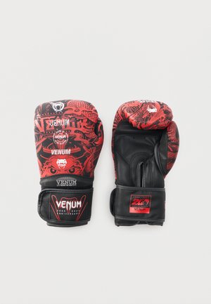 Ζευγάρι κόκκινων και μαύρων γαντιών πυγμαχίας Venum με σχέδιο δράκου και λογότυπα 20ής επετείου, παρουσιασμένα σε λευκό φόντο.
