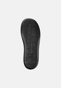 Suola di scarpe in gomma nera con superficie testurizzata, impronta "ENERGIA HUMANA", forma arrotondata e indicazione della taglia 42 sul tallone.