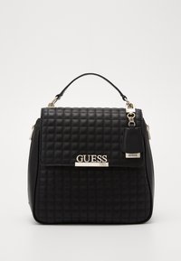 Mustikka pysty käsilaukku, jossa on yläkahva, hopeanvärinen logo ja metalliset yksityiskohdat. Pehmeä pinta ja ryhdikäs muoto.