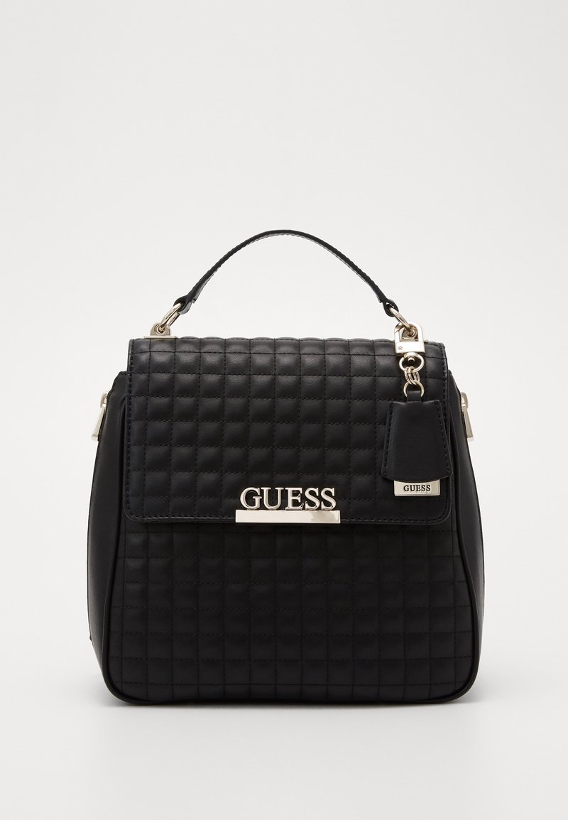 Mustikka pysty käsilaukku, jossa on yläkahva, hopeanvärinen logo ja metalliset yksityiskohdat. Pehmeä pinta ja ryhdikäs muoto.