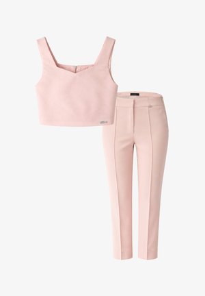 Top crop rosa chiaro senza maniche con scollo quadrato e pantaloni a vita alta su misura abbinati con pieghe frontali e chiusura con cerniera.