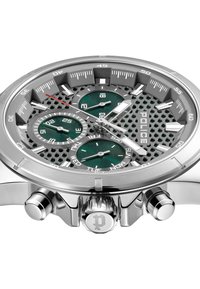 Silverfärgad armbandsur i rostfritt stål med en hexagonal mönstrad urtavla, gröna subdials och en framträdande krona. Graverad "POLICE"-logga på urtavlan.