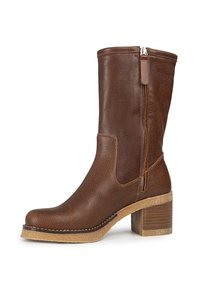 Botas de cuero marrón hasta la rodilla con un acabado texturizado, cierre lateral de cremallera y tacón grueso. Presentan costuras en contraste y una puntera redondeada.