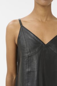 Camisole in ecopelle nera con spalline sottili, caratterizzata da un design a scollo a V e una texture liscia. Linee pulite e cuciture minime evidenziano la costruzione.