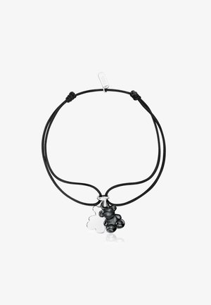 Pulsera ajustable de cordón negro con dos pequeños colgantes de ositos, uno plateado brillante y otro negro mate, colgados lado a lado.