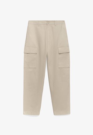 Beżowe spodnie cargo o prostym kroju, z dwiema dużymi bocznymi kieszeniami i zapięciem na guzik w talii. Gładki bawełniany materiał.