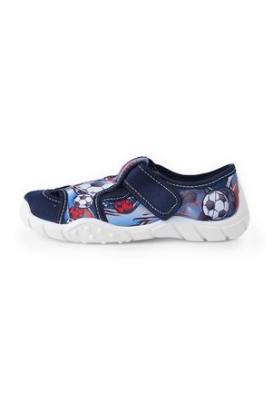 Baskets bleu marine avec une sangle Velcro, dotées d'un motif de ballon de football sur le côté et d'une semelle en caoutchouc texturée blanche.