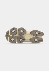 Sneaker outsole featuring a rubber material, beige and gray colors, diamond-shaped pattern, and textured traction surfaces.