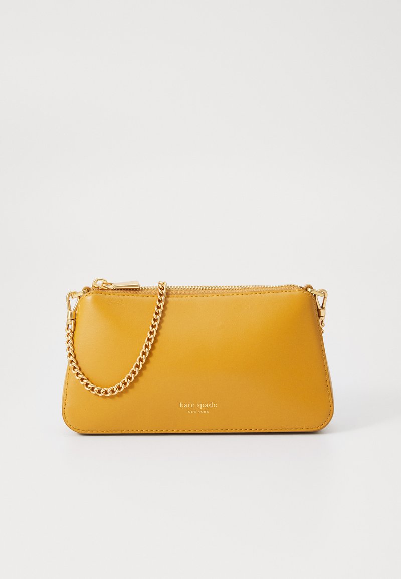 Gul skinn clutchveske med gullkjede, glidelås og preget "kate spade"-logo. Glatt tekstur og rektangulær form.
