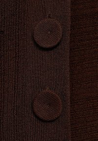 Brauner Strickcardigan mit zwei großen runden Knöpfen. Der Stoff hat ein strukturiertes Muster, das ein geripptes Design betont.