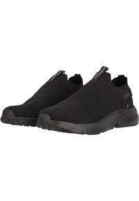 Schwarze Slipper aus Strickstoff mit strukturierter Oberfläche, mit einem niedrigen Design und einer Gummisohle für Grip und Flexibilität.