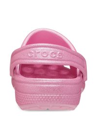 Różowe, błyszczące Crocs z zamkniętym palcem i regulowanym paskiem na pięcie. Miękki materiał plastikowy, teksturowana wkładka oraz lekka, trwała konstrukcja.