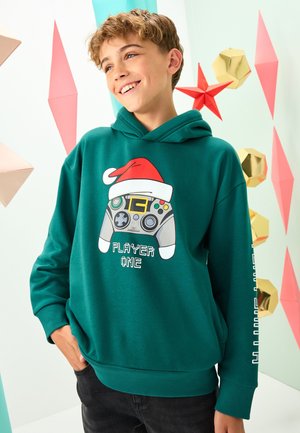 Grüner Hoodie mit einer Grafik eines Spielcontrollers, der eine Weihnachtsmannmütze trägt, mit dem Text "PLAYER ONE", strukturiertem Stoff und Kordelzugkapuze.
