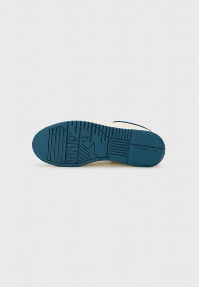 Semelle de chaussure en caoutchouc de couleur bleue avec un motif texturé comprenant des lignes parallèles et des formes géométriques. Design robuste et plat, conçu pour l'adhérence.