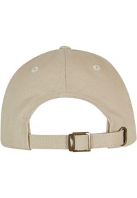 Beige színű pamut baseballsapka, ívelt nappal, állítható pánttal és egy kis gombbal a tetején. A varrás és a hardver azonos árnyalatú.