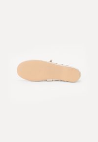 Sandale avec une semelle en caoutchouc beige et un motif floral multicolore sur le dessus. Dotée d'une fine sangle et d'une semelle texturée pour une meilleure adhérence.