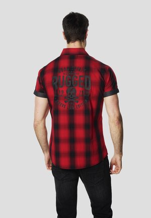 Rdeča in črna karo srajca s kratkimi rokavi z temnim tiskom, na hrbtu je lobanja in napis. Iz bombažnega materiala, z ovratnikom.