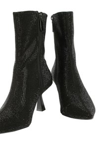 Čierne členkové topánky s priliehavým dizajnom, pokryté malými cvočkami, s špicatou špičkou a blokovým podpätkom. Po bokoch so zipsom na zapínanie.
