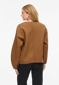 Καφέ υπερμεγέθη πουλόβερ με μακριά μανίκια, κατασκευασμένο από απαλό ύφασμα, με απλό σχέδιο και ίσια κοπή στο τελείωμα.