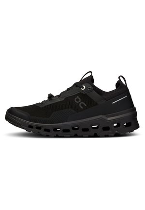 Pantofii sport negri au o parte superioară din plasă respirabilă, o suprafață texturată, un toc gros și căptușit cu decupaje și accente reflectorizante.
