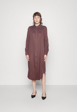 Vestido castanho com botões, gola, detalhes franzidos nos ombros, mangas longas e fendas laterais, feito de um tecido suave.