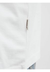 Hvid bomulds t-shirt med et side-søm label med teksten "ORIGINALS". Stoffet har en glat tekstur og en klassisk pasform.