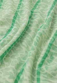 Tissu vert avec un motif abstrait subtil en différentes nuances de vert. La texture semble douce et légère.