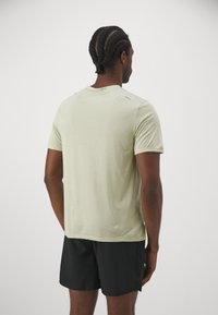 Nike Performance RISE - T-shirt desportiva - olive aura heather/silver
