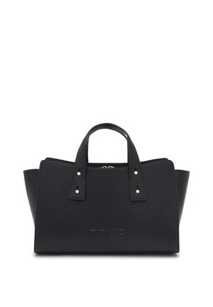 Bolso negro TOUS con dos asas cortas, tachuelas doradas, cierre de cremallera y logotipo en relieve, sobre fondo blanco.