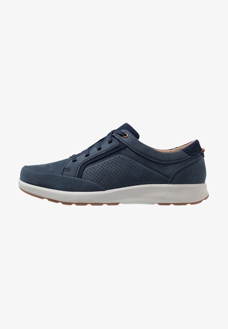 Baskets bleu marine en cuir et en mesh, avec des côtés perforés, des lacets ronds et une semelle en caoutchouc blanc avec un motif en tan.