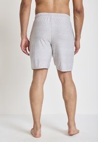 Lichtgrijze shorts met elastische tailleband en een gestructureerde afwerking, tot halverwege de dijen reiken, met een casual fit en zonder zichtbare zakken.