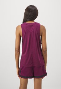 Bordeaux sportieve tanktop met een ontspannen pasvorm, ronde halslijn en gemarkeerde stikdetails, gecombineerd met bijpassende shorts met zwarte accenten.