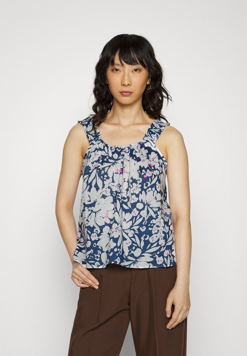 Top sem mangas floral com fundo azul marinho, flores creme e rosa, alças franzidas e um corte folgado. Textura de tecido suave.