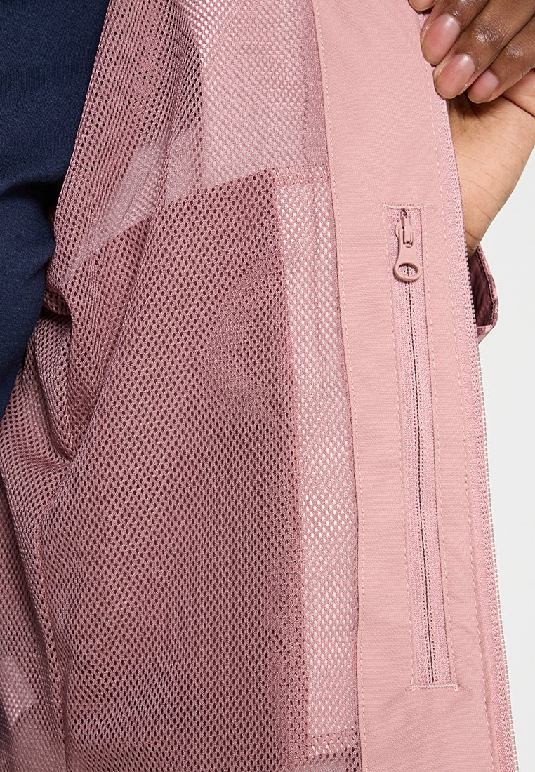 Leichtgewichtige rosa Jacke mit Netzfutter; verfügt über eine sichtbare Reißverschluss-Tasche und strukturierten Stoff. Glattes und atmungsaktives Design.