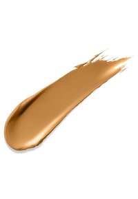 Échantillon de fond de teint liquide avec une texture lisse, teinte brun doré chaud et finition brillante, présentant des bords effilés et un doux fondu.