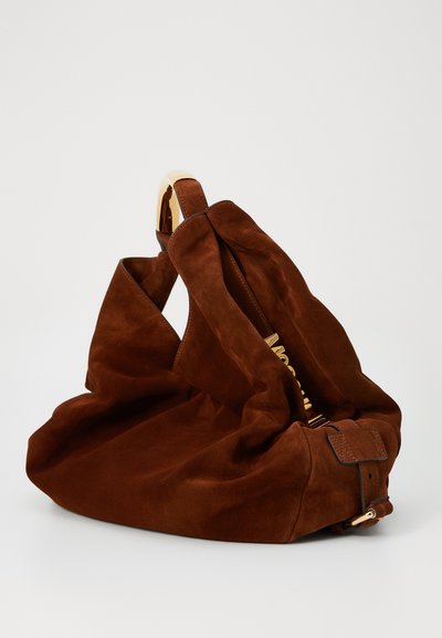 Brun mocka handväska med en avslappnad design, utrustad med ett handtag i guldton och en texturerad, mjuk yta. Märkbar sömdetalj på sidorna.