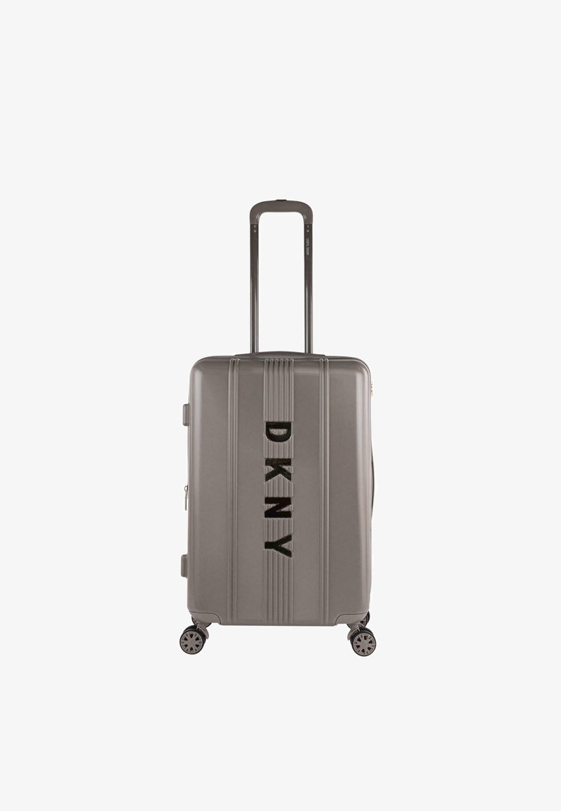 Maleta dura gris con ruedas dobles, estrías verticales y un logotipo negro prominente en la parte frontal. Incluye asa retráctil.