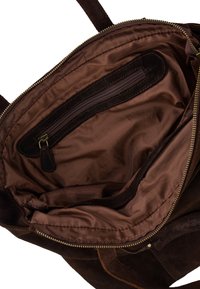 Braune Wildledertasche, geöffnet, um das glatte Stofffutter und eine innere Reißverschlusstasche mit Lederbesatz und Reißverschlusszug zu zeigen.