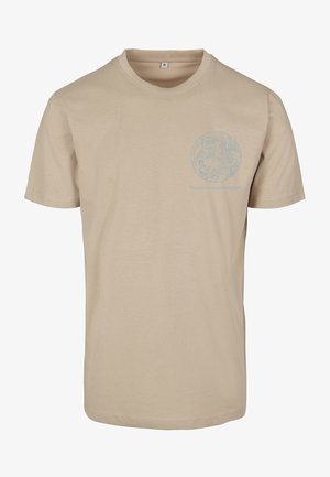 Beež puuvillane lühikeste varrukatega T-särk, mille esiküljel on helesinine ümmargune graafika ja tekst "Lõuna taevane poolkera".