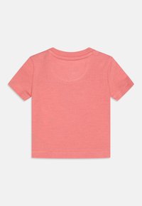 Coral short-sleeve t-shirt made of soft cotton, featuring a rounded neck, stitched hems, and a smooth texture. No prints or patterns.