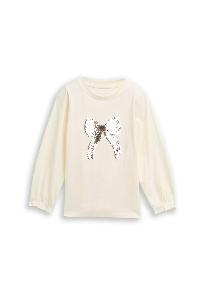 Crème lange mouwen shirt met elastische manchetten, geïllustreerd met een glanzende pailletten strik in zilver en wit in het midden. Zachte stoftextuur.